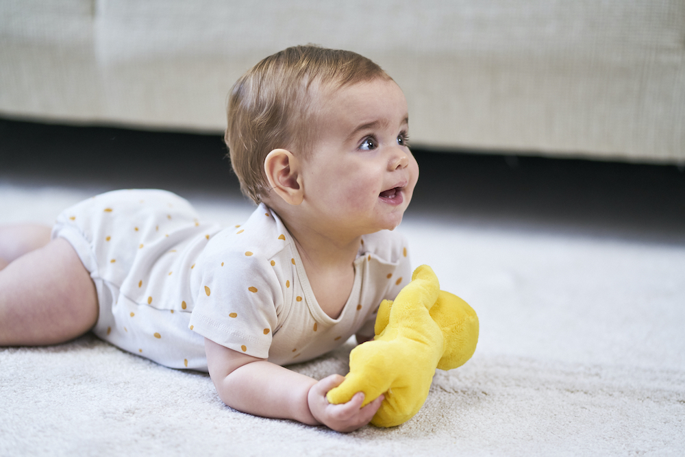 baby ligt op buik op het tapijt