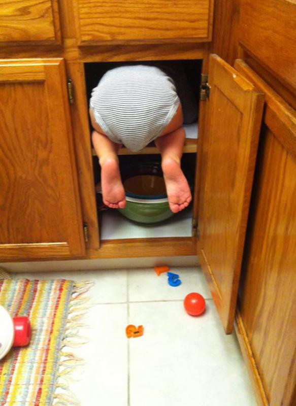 enfant dans un placard de cuisine